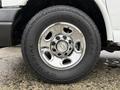 Close-up of a 2009 Chevrolet Express wheel featuring a shiny chrome rim and a black tire with the words Adventuro AT AW and GT Radial printed on it