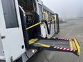 A 2017 Chevrolet Express with an open rear door and a yellow wheelchair ramp extending outward