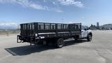 A 2019 Ford F-550 truck with a flatbed and metal sides parked on a lot