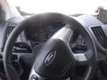 A close-up view of the steering wheel of a 2017 Ford Transit featuring the Ford logo and dashboard instruments visible behind the wheel