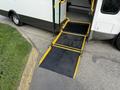 A 2020 Chevrolet Express with a deployed wheelchair ramp extending from the side door