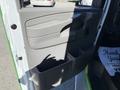 The interior door panel of a 2013 Chevrolet Express featuring a storage compartment and a handle