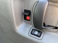 A close-up of the door handle and window controls on a 2014 Chevrolet Express showing a black handle and two switches with red and black indicators