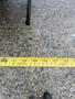 A yellow measuring tape extended to show a measurement of 135 inches, laid flat on a textured surface