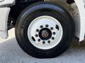 Close-up of a 2021 Hino 338 tire showcasing a white rim with multiple lug bolts and a black tire tread