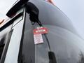 A close-up of a 2016 Grande West Vicinity bus showing a sticker with months labeled January to May and a red certificate of approval displayed on the windshield
