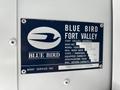 A metal identification plate for a 2022 Blue Bird BB Conventional bus listing details such as model year body number state capacity and specifications