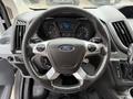 Steering wheel of a 2017 Ford Transit with a Ford logo control buttons and instrument panel visible behind it