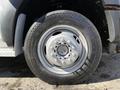 Close-up of a tire from a 2011 Ford F-550 showing a silver wheel rim with multiple lug nuts and an all-season tread pattern