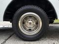 A close-up of a chrome wheel of a 2017 Ford Econoline with a black tire featuring an all-terrain tread pattern