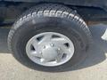 The image shows a close-up of a tire on a 2009 Ford Econoline featuring a silver alloy wheel with a distinct tread pattern and clear brand markings on the tire sidewall