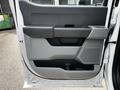 The interior door panel of a 2024 Ford F-550 featuring a sleek design with a gray color scheme and storage compartments