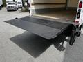 A black steel liftgate is lowered at the rear of a 2018 Hino 195 truck showing a textured surface designed for loading and unloading cargo