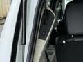 A 2017 Dodge Grand Caravan features a control panel with buttons near the driver's seat and a plush black interior on the passenger side