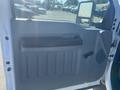 Interior door panel of a 2014 Ford F-250 SD featuring a handle and storage area