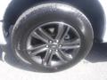 A close-up view of a black alloy wheel and tire from a 2022 Ford F-150 featuring five spokes and a brand name on the tire sidewall