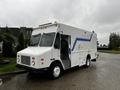 A 2005 Workhorse W-Series delivery truck with a white exterior and blue stripe design parked with its side door open