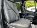 Front interior of a 2019 Mercedes-Benz Sprinter showing two black upholstered seats with seatbelts and an armrest