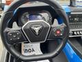 Close-up of the steering wheel of a 2020 Polaris Slingshot featuring control buttons for media and cruise on the left and a red ignition button on the right