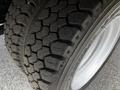 Close-up of a tire from a 2018 Isuzu NPR showcasing a rugged tread pattern and white rim