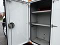 Open door of a white 2013 International DuraStar truck revealing empty shelving inside