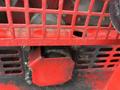 Close-up view of a John Deere 1585 Terrain Cut engine compartment with visible red metal casing and ventilation slots showing mechanical components inside