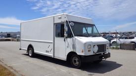 A 2011 Ford Econoline van with a white exterior featuring a large cargo area and a driver's side mirror