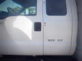 A 2005 Ford F-750 commercial truck with a white exterior and a visible driver's side door featuring a black handle and a weight label indicating 9000 KGS