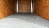 Interior view of a cargo area in a 2018 Mitsubishi Fuso FE with wooden panels and a concrete floor