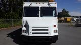 A white 2004 Freightliner MT45 delivery truck with a flat front, large windshield, and amber light on the roof