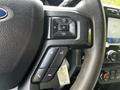 Steering wheel controls of a 2020 Ford F-350 Super Duty featuring buttons for volume, phone functions, and navigation settings