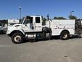 A white 2007 International 7300 truck with a utility body and compartments on the side for tools and equipment