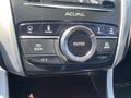 A close-up of the interface controls in a 2017 Acura TLX featuring a central dial and buttons for navigation, phone settings, and audio functions