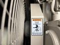 A warning label on a 2005 Katolight SED60FPJ4 generator indicating that the unit starts automatically and advising to switch it off before servicing