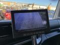 A display monitor showing a rearview camera feed with a blurry view of a surface