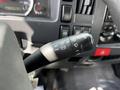 A close-up of the control lever inside a 2016 Isuzu NQR featuring various switches for lights and windshield wipers