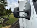 Close-up of the side mirror of a white 2017 Ford Econoline van showing its distinctive rectangular shape and black color