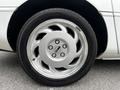 Close-up of a silver alloy wheel on a 1992 Chevrolet Corvette showcasing five circular spokes and a central logo