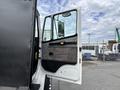 A 1998 Freightliner FL80 truck with its driver's side door open showcasing the interior door panel and handle