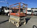 A 2010 SkyJack SJ scissor lift with an orange and gray frame elevated slightly above ground level
