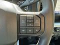 Steering wheel control panel of a 2023 Ford F-550 featuring buttons for navigation phone and menu functions