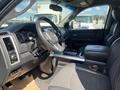 Interior of a 2011 RAM 1500 with a black steering wheel center console and bucket seats showing a modern design and layout