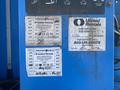 A blue metal panel with safety inspection stickers and a service information label for a 1997 Genie S-65 4X4 aerial work platform