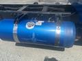 A blue fuel tank with decorative designs and metal straps attached to the chassis of a 2008 Peterbilt 340 truck