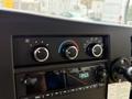 Control panel of a 2020 Chevrolet Express featuring climate control knobs and a digital clock display