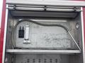 A 2006 E-One Typhoon fire truck compartment with a metal surface featuring a hose connection and a mounted bracket