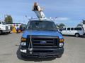 A blue 2009 Ford Econoline van with a bucket lift attached on the roof facing forward
