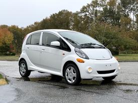 A white 2013 Mitsubishi i-MiEV electric car with a compact design showcasing rounded edges and unique headlights