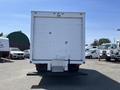 A white 2008 Ford F-450 SD box truck viewed from the rear with a flatbed and closed doors