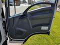 A close-up of the open driver's side door of a 2016 Isuzu NPR showcasing the interior panel and handle